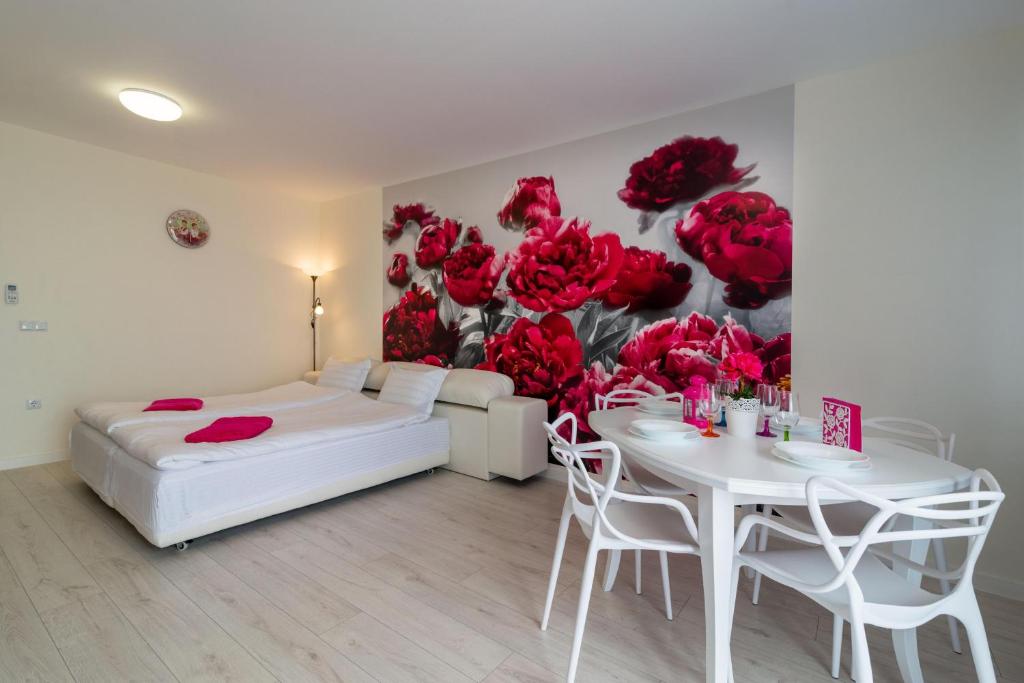 ゴールデン・サンズにあるSea Star Kabakum Apartmentsのベッドルーム1室(ベッド1台、テーブル、赤いバラの壁画付)