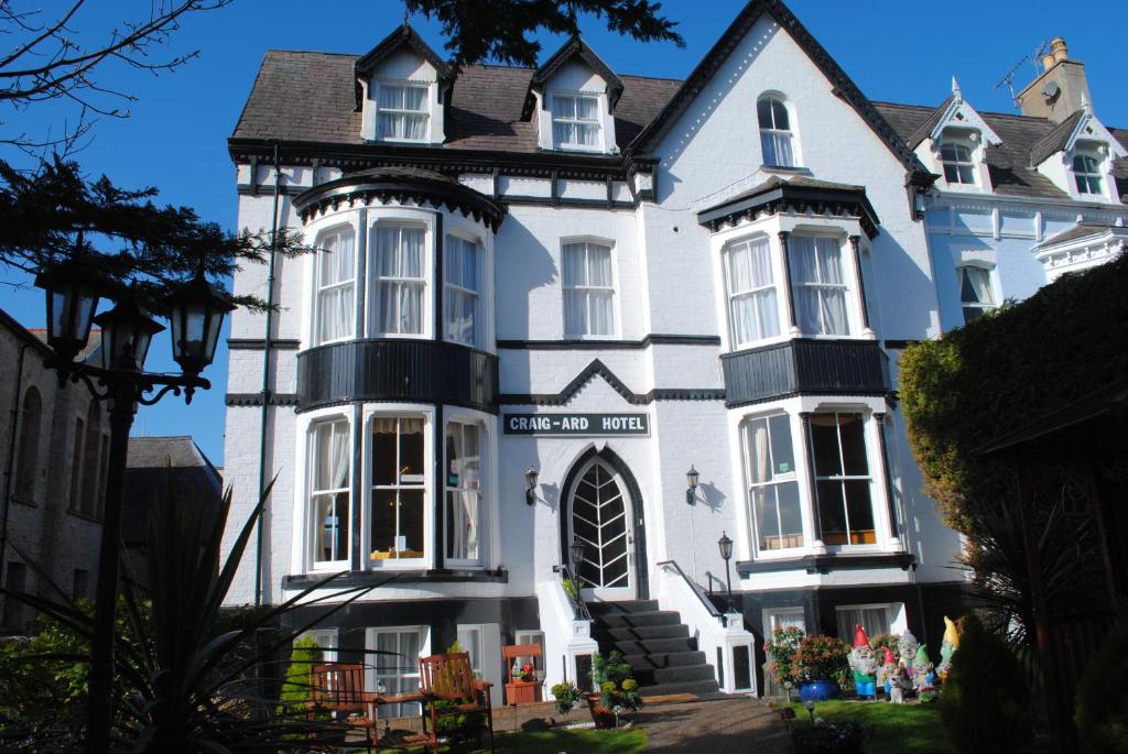 a large white house with a black roof at Craig-Ard Hotel in Llandudno