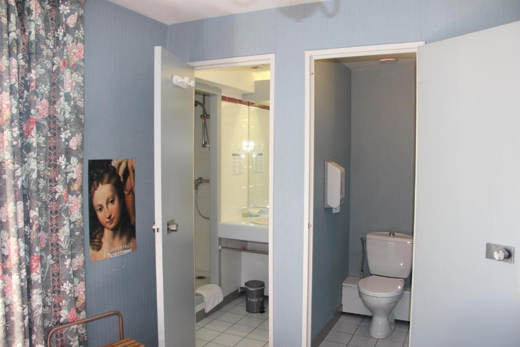 a bathroom with a toilet and a sink at Hôtel Le Catala in Beaudéan