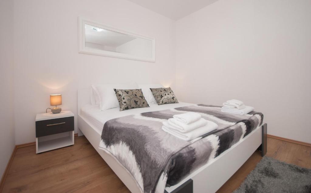 ein Schlafzimmer mit einem Bett mit einer schwarzen und weißen Decke in der Unterkunft Apartment Slad in Kaštela