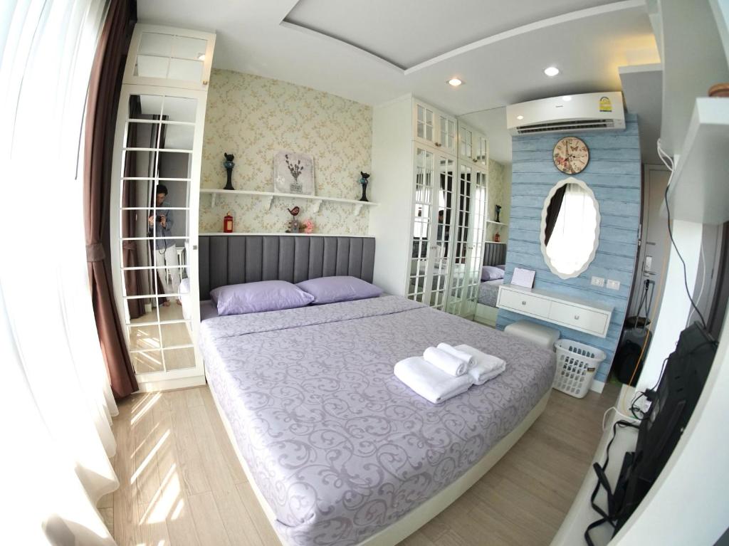 um quarto com uma cama grande e um espelho em The Patio Bangsaen em Bangsaen