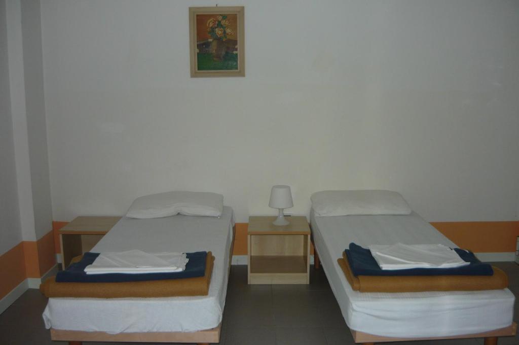 Postel nebo postele na pokoji v ubytování Ostello Domus Augusta Aquileia