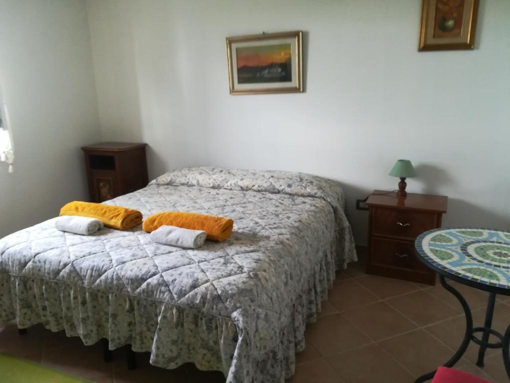 Bed and breakfast sas Damas في Chiaramonti: غرفة نوم عليها سرير وفوط