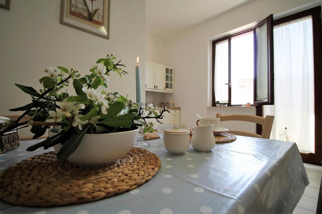 einen Esstisch mit einer Blumenvase darauf in der Unterkunft A casa di Emy by Holiday World in Pulsano