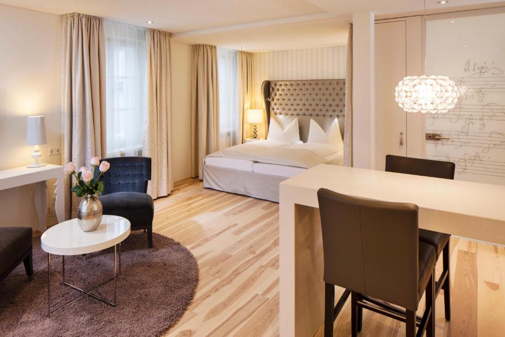 a hotel room with a bed and a table and chairs at Hapimag Ferienwohnungen Salzburg in Salzburg