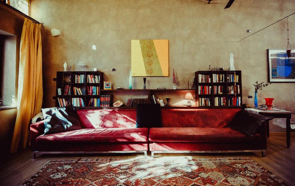 ラヴェンナにあるA Casaの本棚付きのリビングルームの赤いソファ