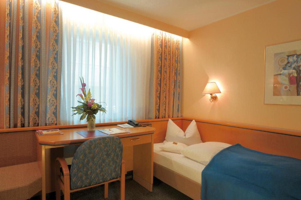 Postel nebo postele na pokoji v ubytování Ringhotel Loew's Merkur