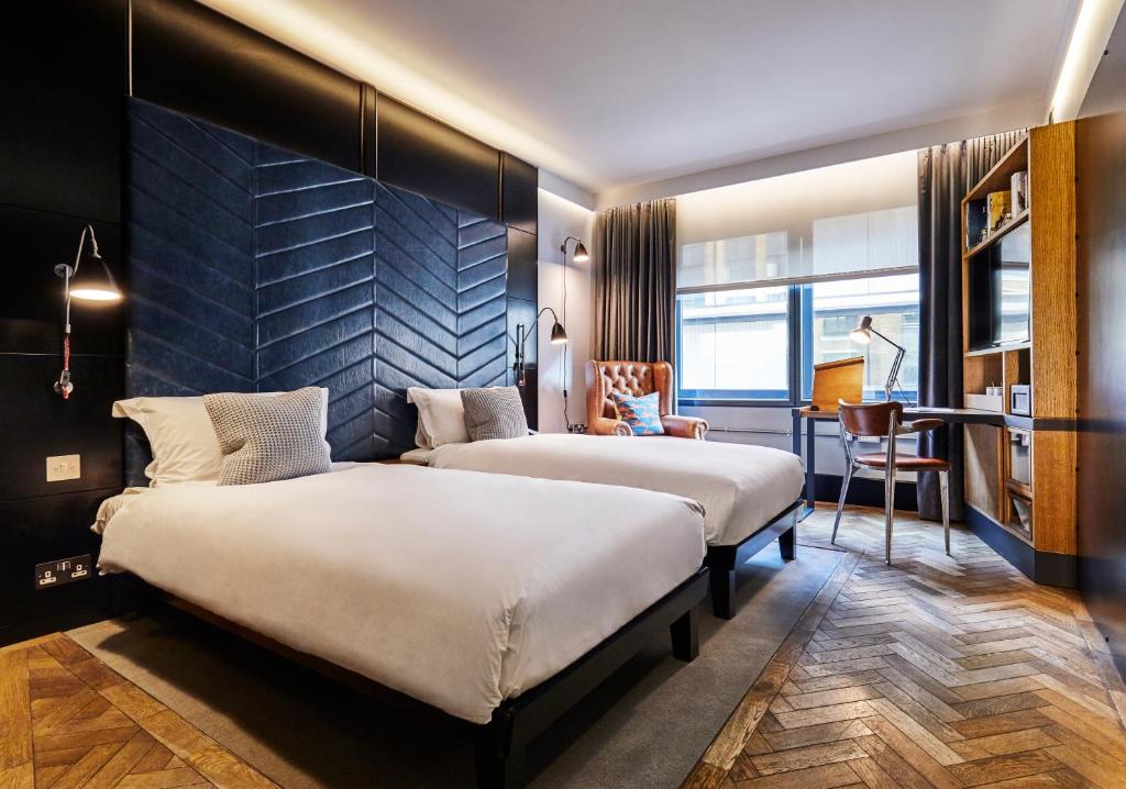 um quarto de hotel com duas camas e uma secretária em The Hoxton, Shoreditch em Londres