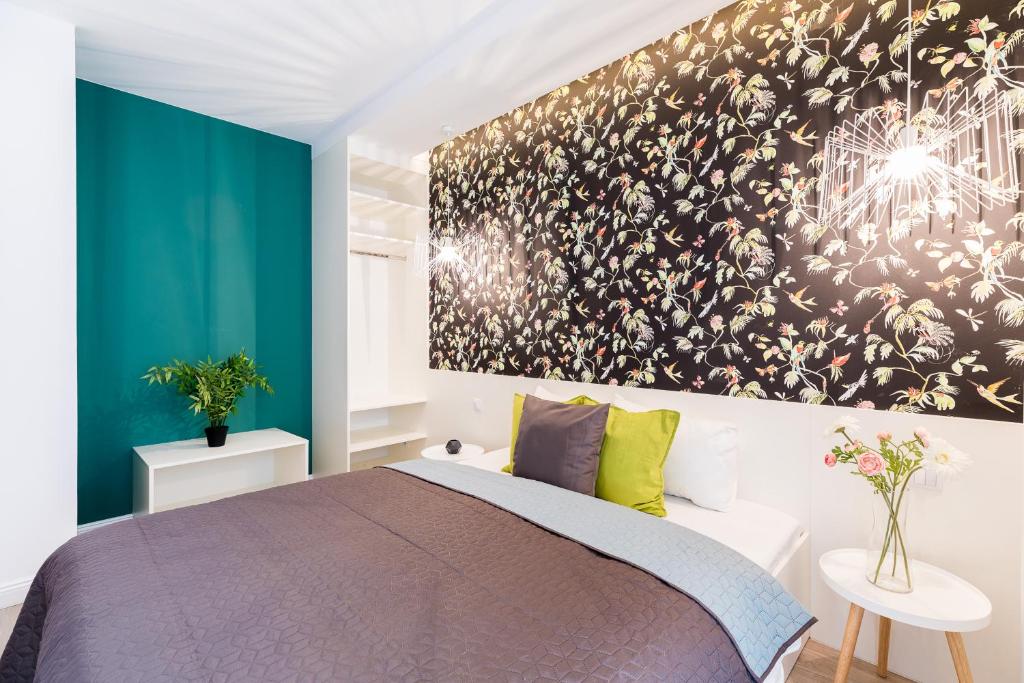 - une chambre avec un lit et une peinture murale dans l'établissement Vagabond Broadway, à Budapest
