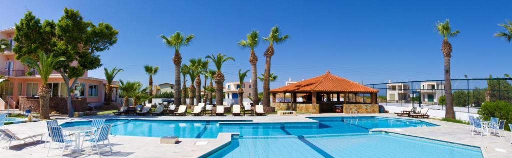 a swimming pool with a gazebo and palm trees at Hotel Klonos - Kyriakos Klonos in Aegina Town
