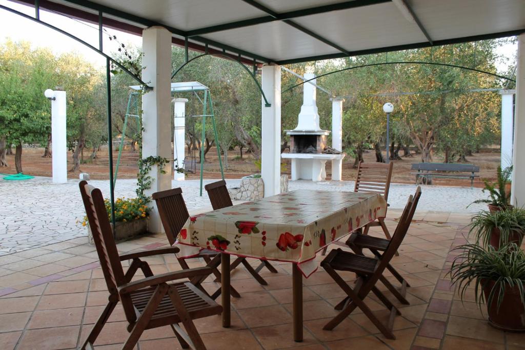een tafel en stoelen op een patio met een open haard bij Villetta Salento Lu Trolitu in Specchia