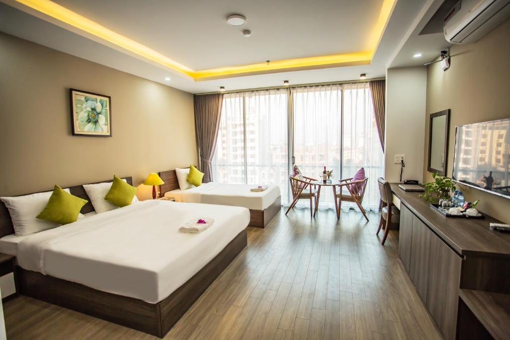 Bắc NinhにあるHana 2 Apartment & Hotel Bac Ninhのベッドとテーブルが備わるホテルルームです。