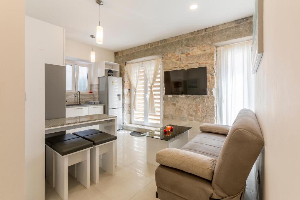 a living room with a couch and a kitchen at Apartment DeLux in Split