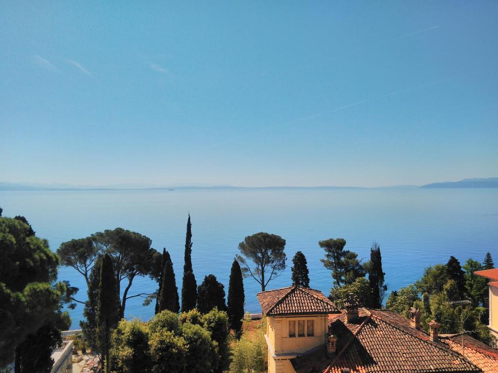 a view of a house and trees and the ocean at Room Anthea 2 in Opatija