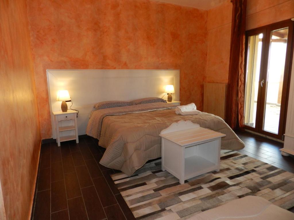 恩納的住宿－Enna Cerere，一间卧室配有一张床、两盏灯和一个窗户。