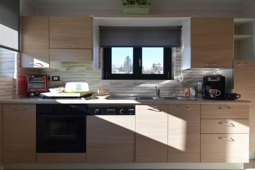 a kitchen with wooden cabinets and a window at B&B Culla Dell'Aquila in LʼAquila