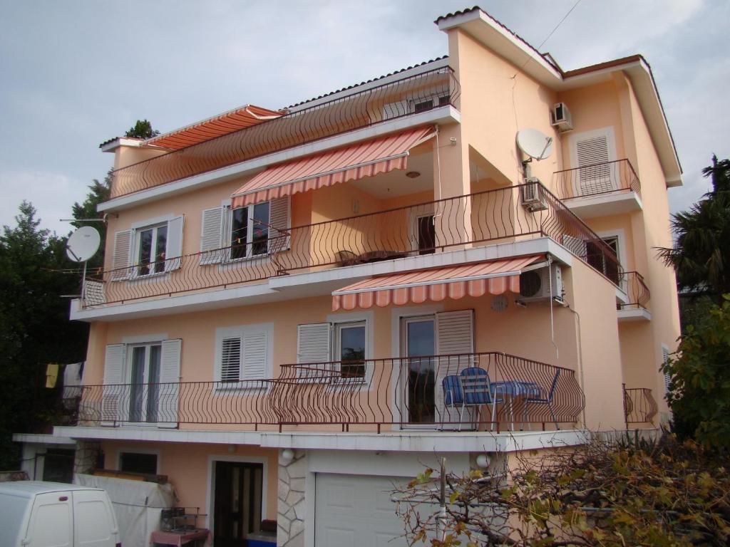 a building with balconies and tables and chairs on it at Apartments Melita in Crikvenica