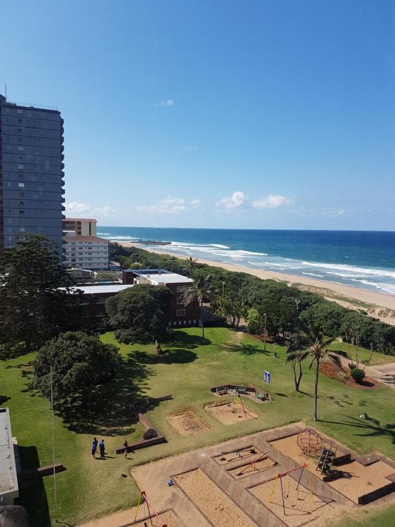 a park on the beach with the ocean in the background at Beach frond apartment in Amanzimtoti
