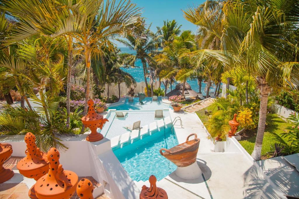 a resort with a swimming pool and palm trees at Villas Fasol Huatulco in Santa Cruz Huatulco