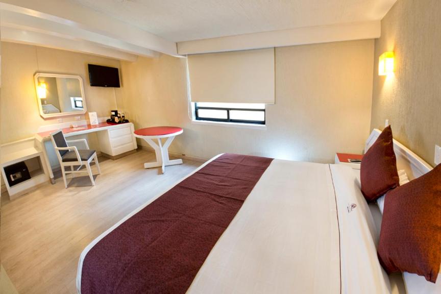 a large bedroom with a large bed and a desk at Hotel Regente in Mexico City