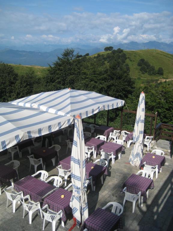 grupa stołów i krzeseł z parasolami w obiekcie Albergo Casa Della Neve w mieście Stresa