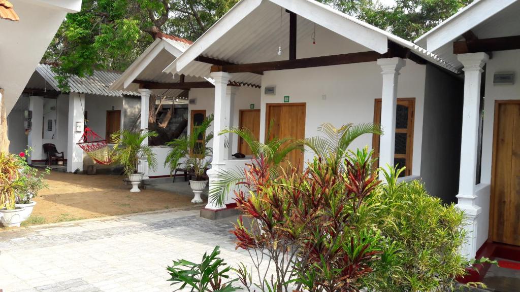 a house with a porch and plants in front of it at The Bavarian Resort in Arugam Bay