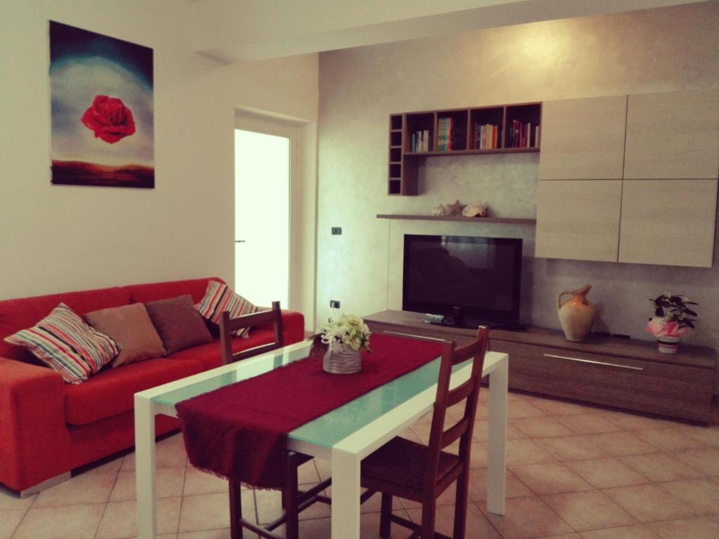 a living room with a red couch and a table at Strada dei Frutteti in Tavullia