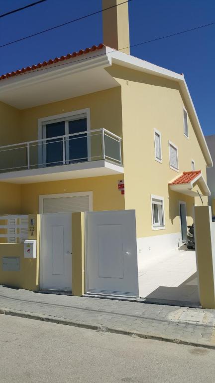 une grande maison jaune avec deux portes de garage dans l'établissement A.V Holidays, à Fernão Ferro