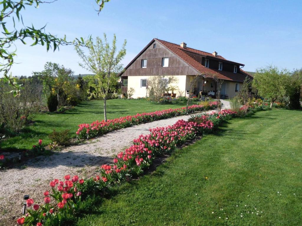 a house with a row of flowers in a yard at Apartment Boroví in Karlštejn