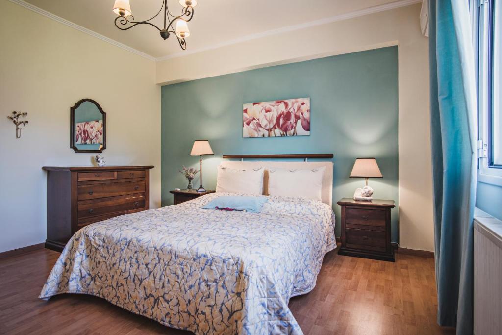 ein Schlafzimmer mit einem Bett und zwei Nachttischen in der Unterkunft Birdsing Cottage in Dassia
