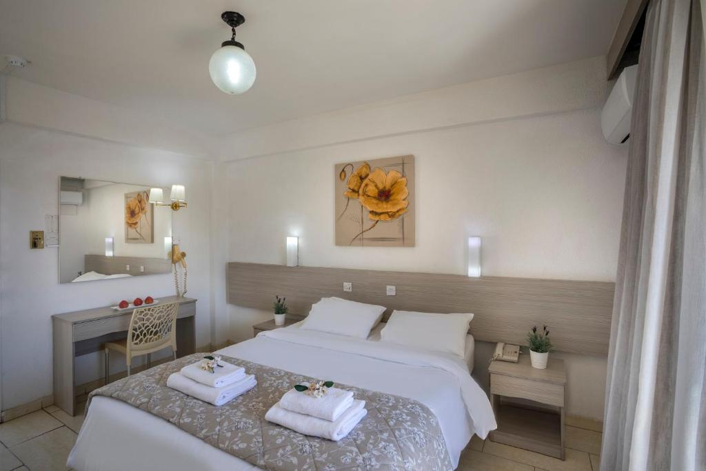 Pokój hotelowy z 2 łóżkami i biurkiem w obiekcie Cactus w Larnace