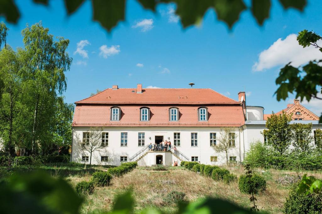 a large white building with a red roof at COCONAT-a workation retreat & Coworking in Hagelberg