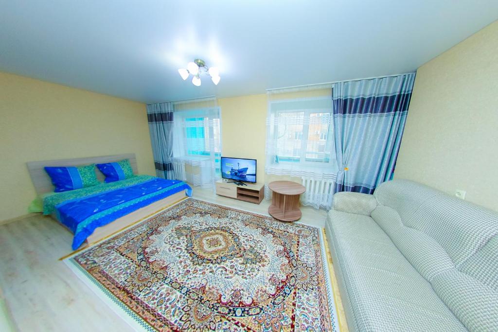 阿斯克卡明諾戈斯克的住宿－Apart on Slavskogo 14，一间卧室配有一张床、一张沙发和一台电视。