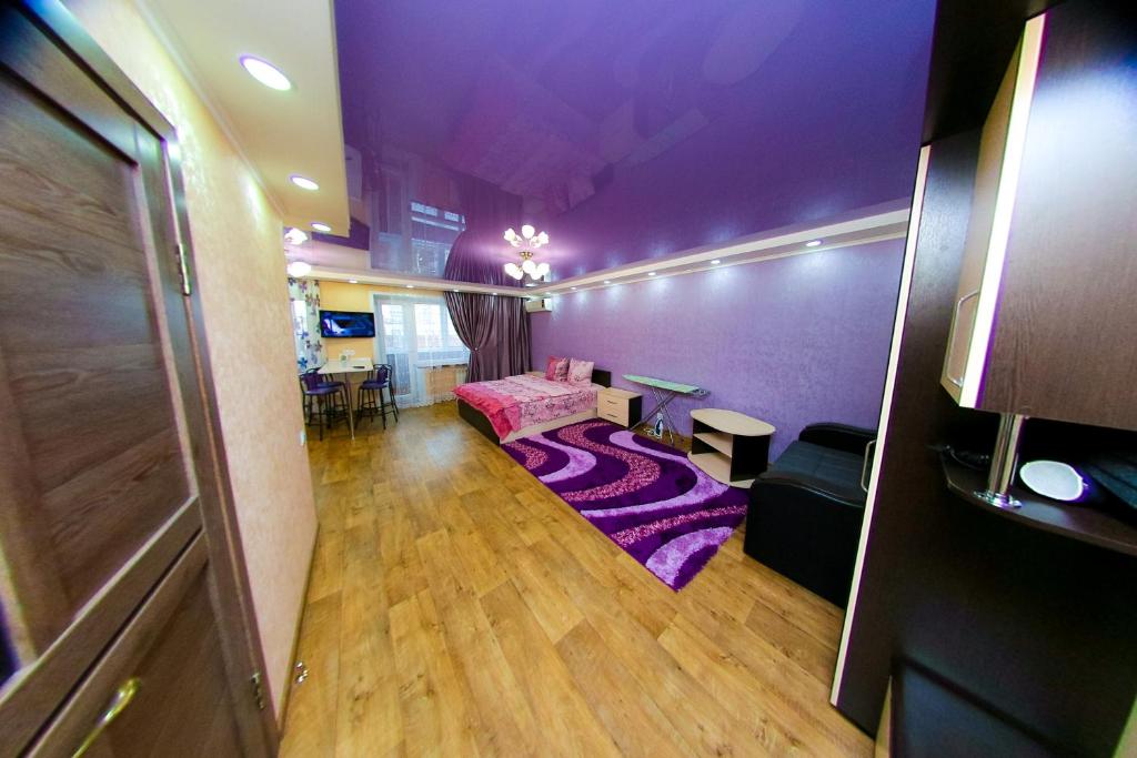 een woonkamer met paarse muren en een paarse vloer bij ApartLux on Slavskogo 26 View River in Öskemen