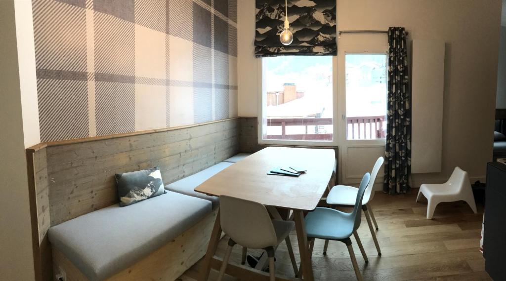 comedor con mesa, sillas y ventana en Appartement familial - La Tania en La Tania