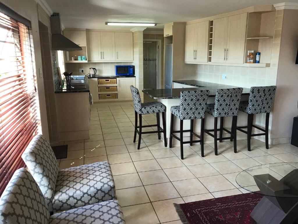 a kitchen with a table and chairs in a room at Sandy Bottoms in Jeffreys Bay