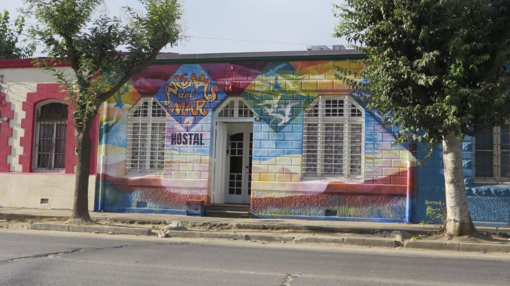 um edifício com um mural colorido ao lado em Hostal Arenas del Mar em Viña del Mar