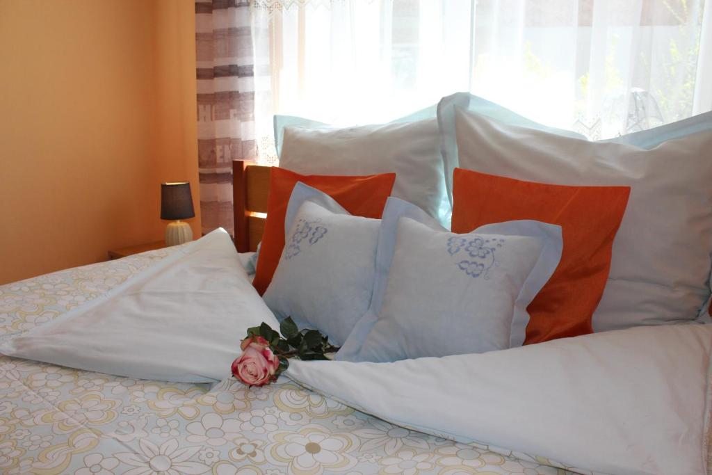 カルパチにあるPokój Kameralny- De Luxe z oddzielnym wejsciemの白い枕と花が付いたベッド