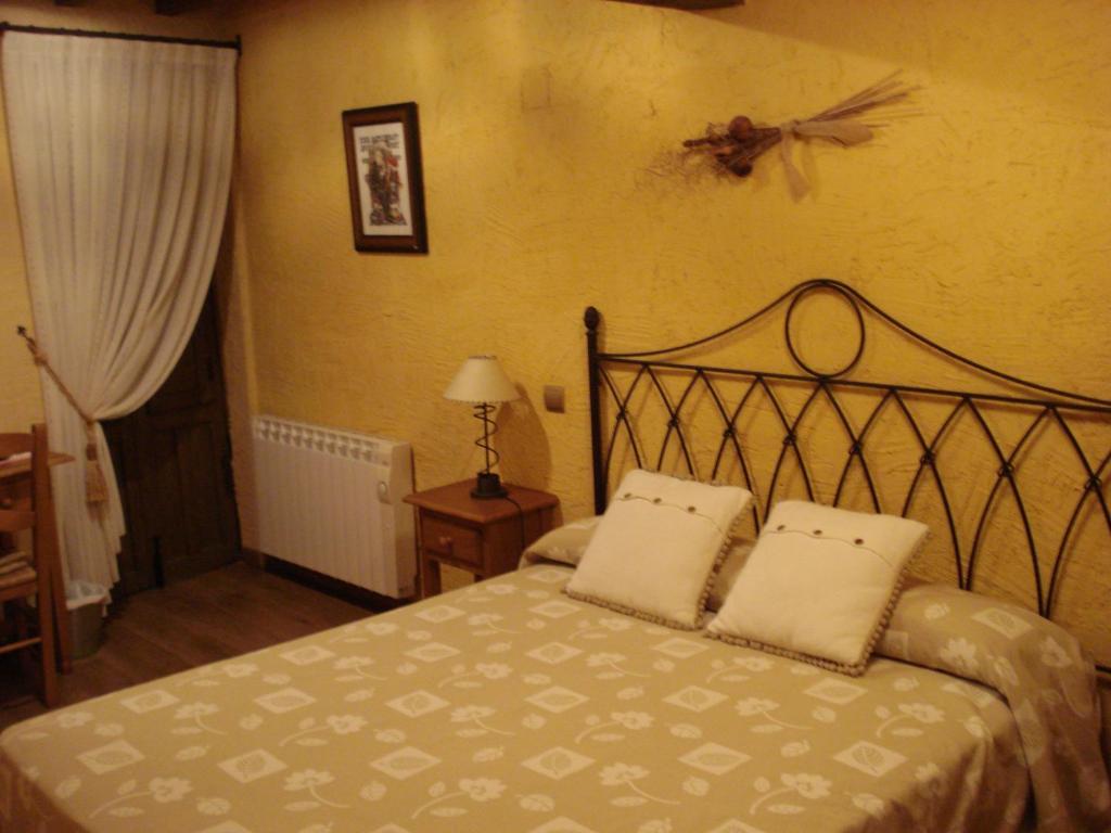 a bedroom with a bed with two pillows on it at El Balcón de Mogarraz in Mogarraz