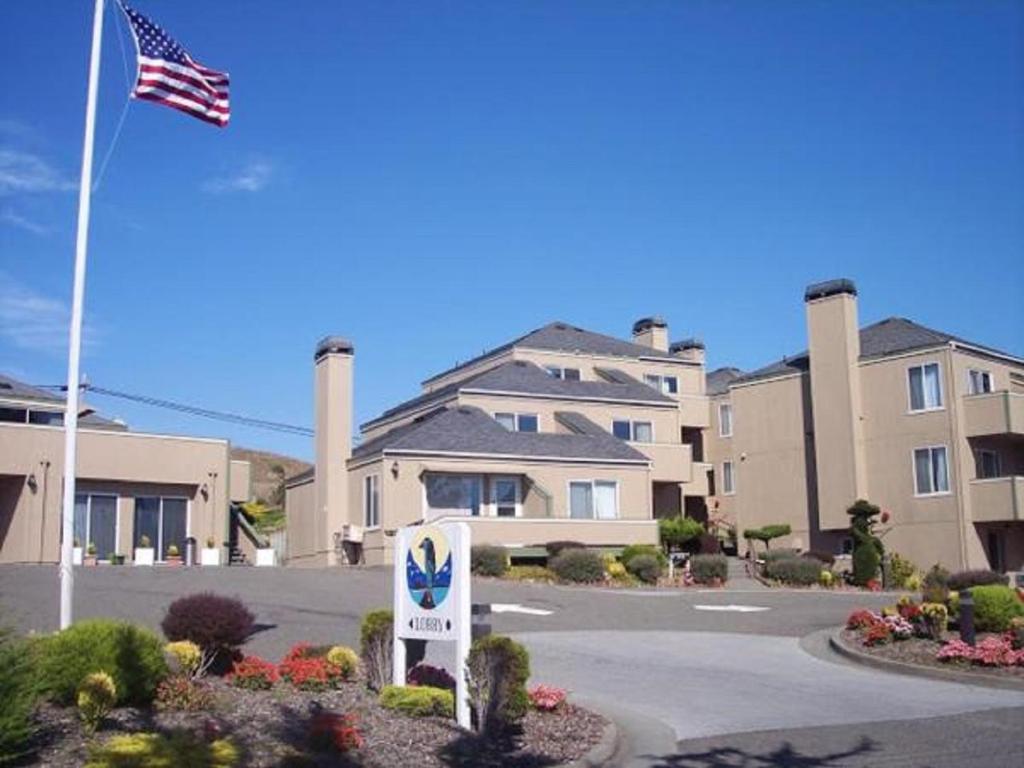 una señal frente a un edificio con bandera en Bodega Coast Inn and Suites, en Bodega Bay