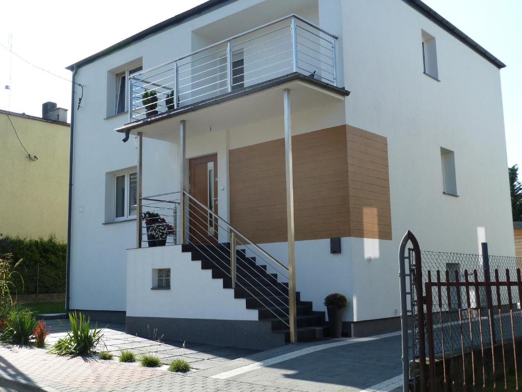 ブワディスワボボにあるStudio 2-pokojowe Magdaの階段とバルコニー付きのホワイトハウスです。