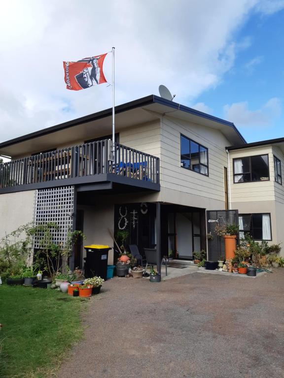 a house with a flag on top of it at Murrays On Mary in Whangamata
