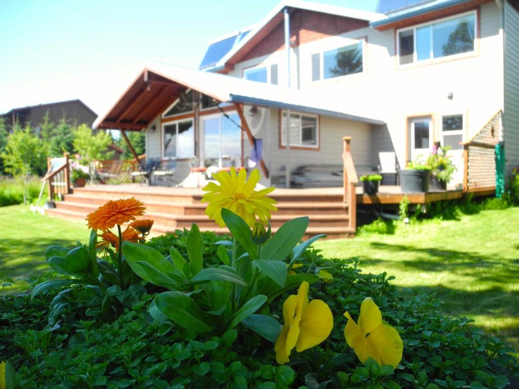 una casa con terraza y flores en el patio en Bay Avenue Inn, en Homer