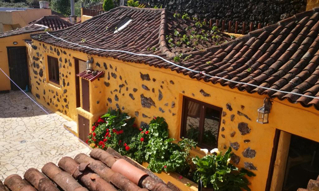 un bâtiment orange avec des fleurs sur le toit dans l'établissement Country private studio, à El Amparo