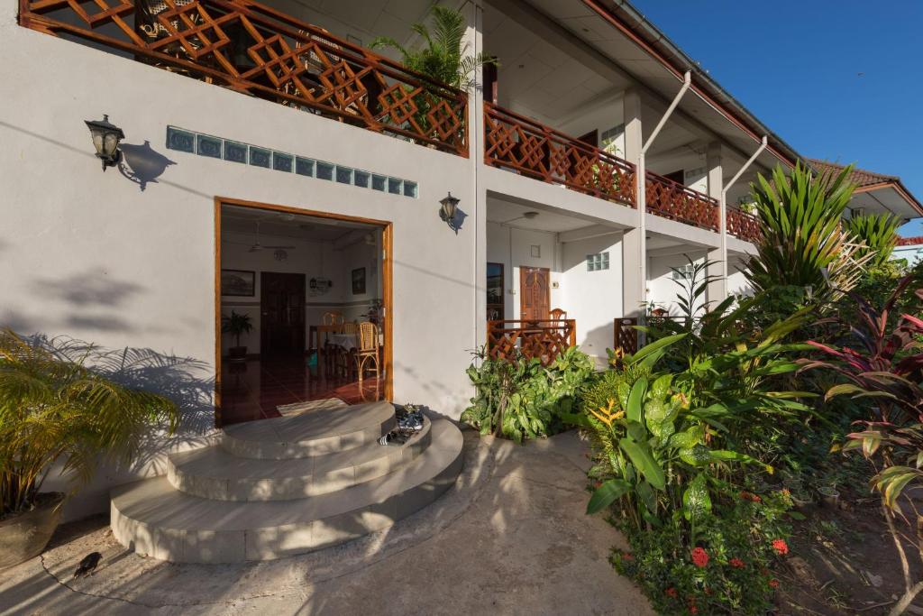 ein Haus mit einer Treppe, die auf eine Terrasse führt in der Unterkunft BABA Guesthouse in Don Det