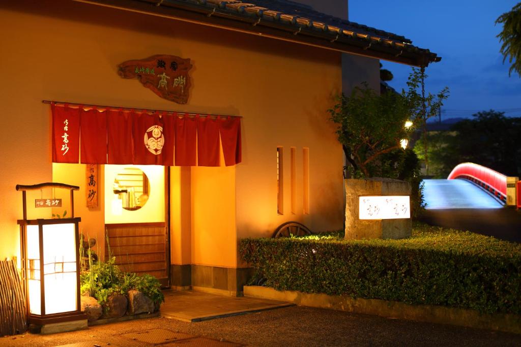 ein Haus mit einem Schild an der Tür und einem Pool in der Unterkunft Onyado Takasago in Ureshino