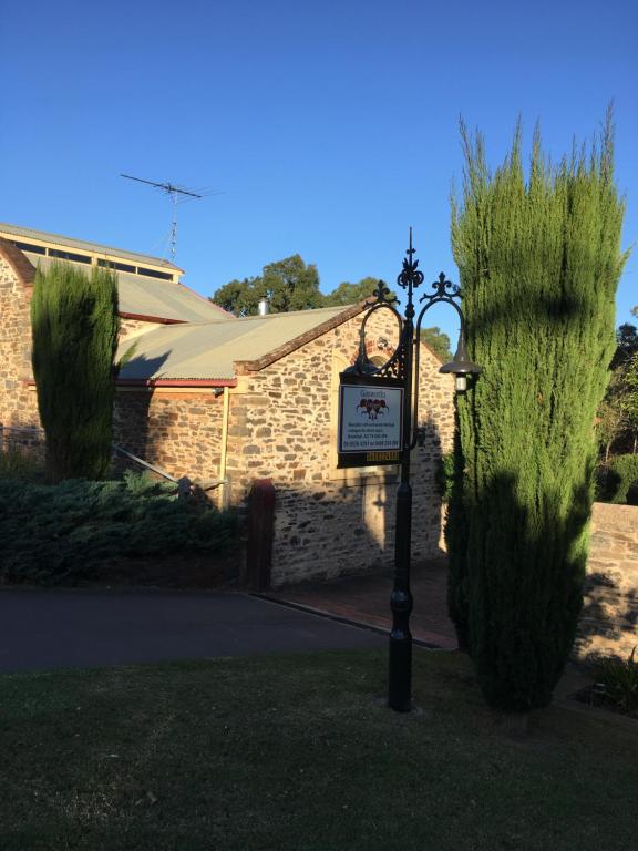 a sign in front of a building with tall grass at Gasworks B&B Cottages in Strathalbyn