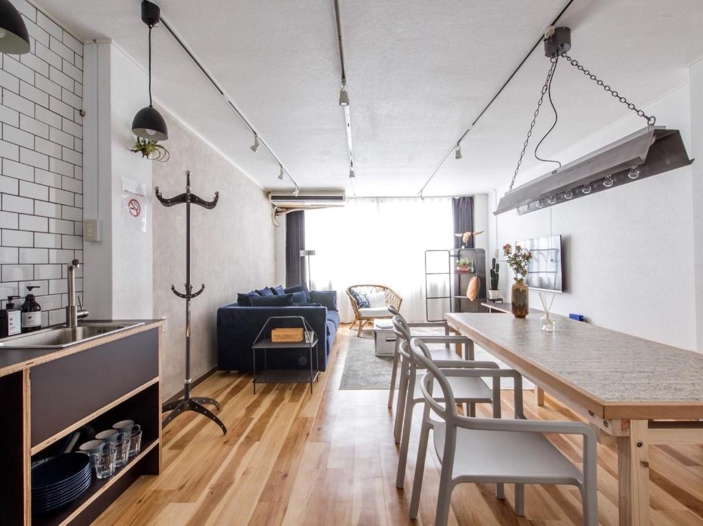 a kitchen and living room with a table and chairs at nid NAMBA Station House in Osaka