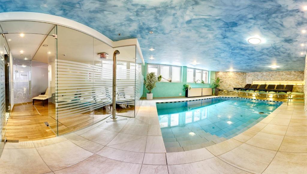 uma grande piscina com um tecto azul em Hotel Leitner em Mühlbach