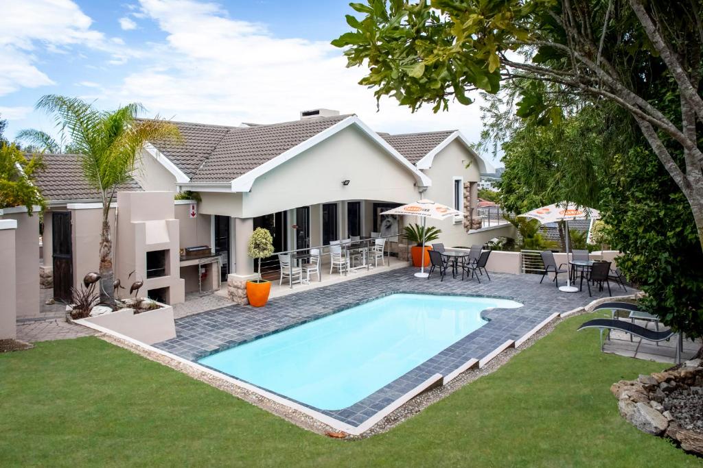 a swimming pool in the backyard of a house at Orange Inn Knysna in Knysna